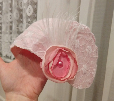 a homemade pink hat with a feather